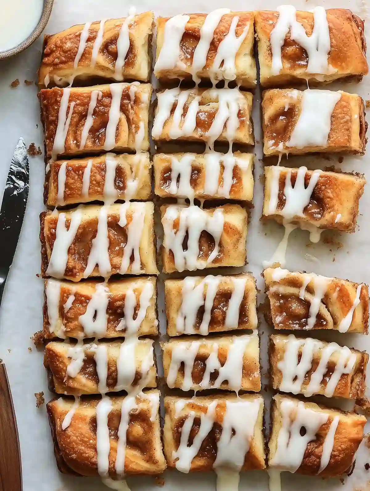 Slices of cinnamon roll focaccia with glaze on marble surface, inviting and fresh.