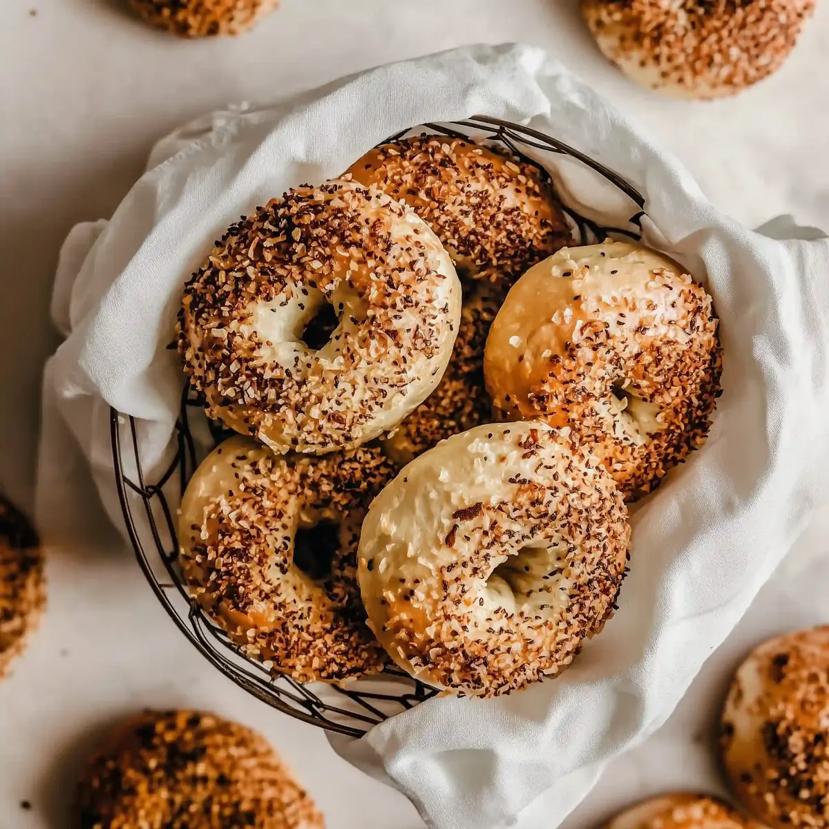 Wire basket with golden brown onion bagels topped with fried onion crumbs.