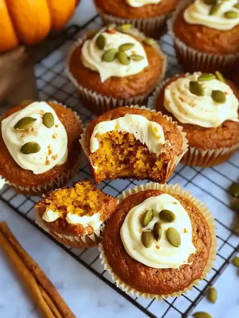 Freshly baked pumpkin muffins with cream cheese filling and pumpkin seeds.