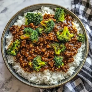 Bowl of steamed rice topped with brown beef, broccoli, and honey garlic sauce.