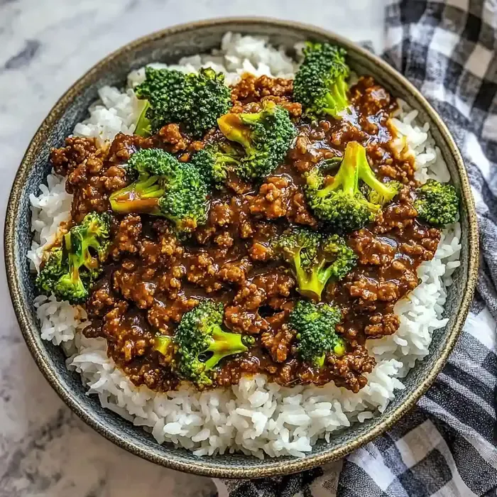 Bowl of steamed rice topped with brown beef, broccoli, and honey garlic sauce.