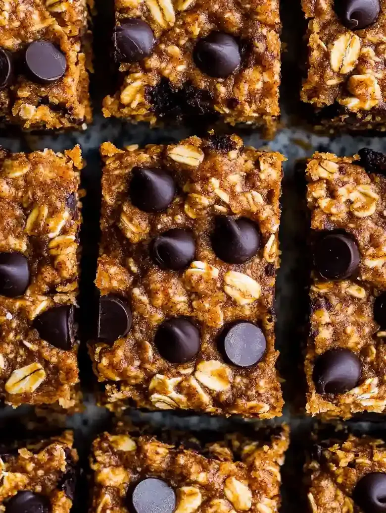 Pumpkin chocolate chip oatmeal bars arranged in a grid on a marble surface.