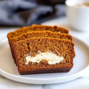 Slices of spiced pumpkin cream cheese bread on a white plate.