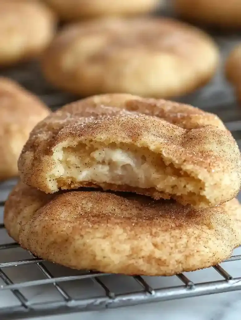Freshly baked cream cheese snickerdoodles on a cooling rack.
